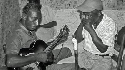 Blues musicians playing a guitar and harmonica