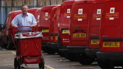 A postal worker pushes a cart at a Royal Mail sorting office in Loughborough