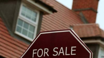 'For sale' sign in front of house