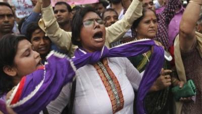 An Indian protester ties a knot around her neck as others shout slogans seeking death sentence for the juvenile convict who was earlier given a three year term in a reform home