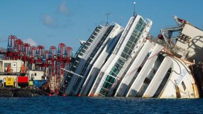 Engineers work near the wreckage of the Costa Concordia