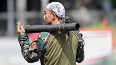 A Philippine soldier carriers a mortar