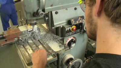 A young man using an industrial drill