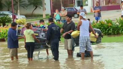 Looters with a shopping trolley full of supplies and exercise equipment