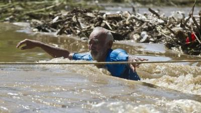 Man wades through floodwaters