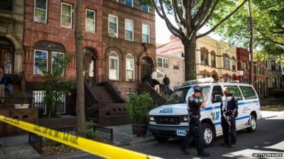 Policemen stand guard outside the home of Cathleen Alexis