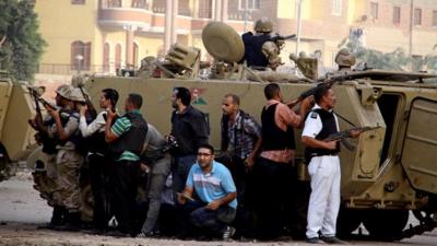 Egyptian security forces take cover during clashes with suspected militants (not pictured) in the town of Kerdasa