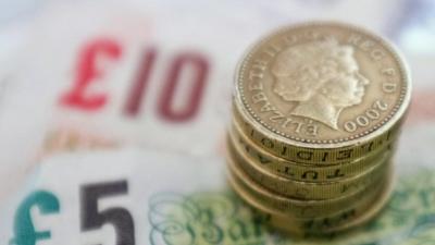 Stack of pound coins on pound notes