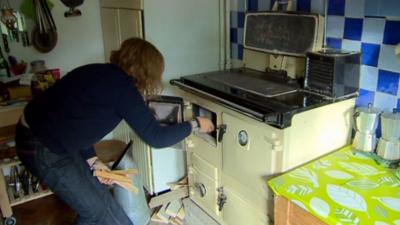 A woman lighting a cooker