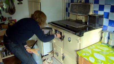 A woman lighting a cooker