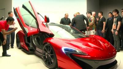 Man photographing a Mclaren supercar