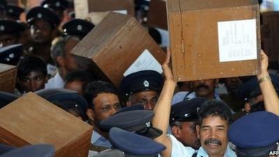 Sri Lankan election workers carry ballot boxes before boarding buses as they prepare to go to polling centres in Jaffna (20 September 2013)