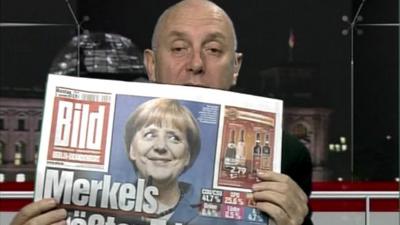 Steve Evans holds German newspaper