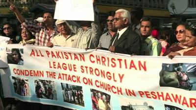 People holding up a banner in protest to the bombing of a Church on Sunday