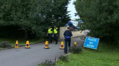 Police at the entrance to the farm