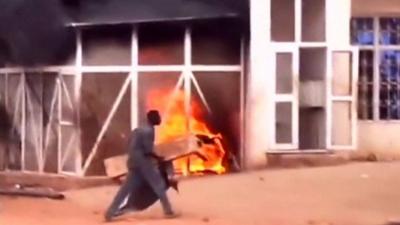 A man walks past a burning petrol station during a protest against a cut in fuel subsidies in the Omdurman district of Khartoum