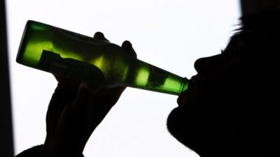 A man drinks from a bottle of beer