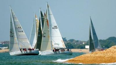 The class three yachts tack away from the beach in the eastern Solent off Alverstoke