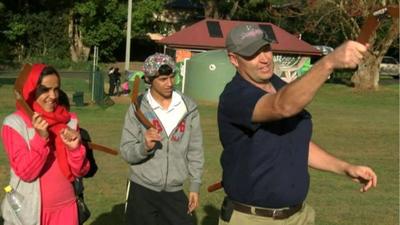 Family learning to throw boomerang