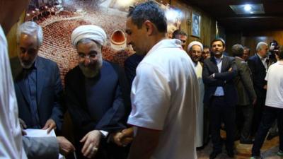 Omid Namazi shakes hands with Iranian president Hassan Rouhani in Tehran.