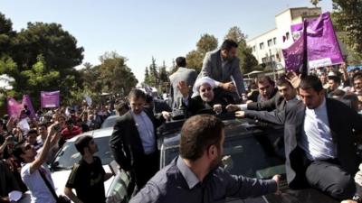 Iranian President Hassan Rouhani waves to supporters in Tehran