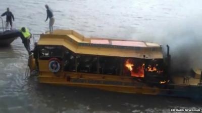 People on roof of Ducktours boat on fire