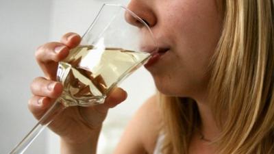 A woman drinking a glass of wine