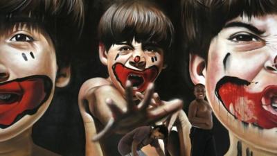 Boys plays in front of a painting by Brazilian artist Zack that is part of the ArtRua street art exhibition in Rio de Janeiro, Brazil
