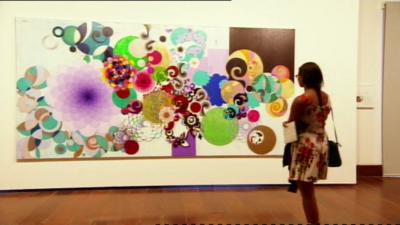 A woman admires a painting in Brazil