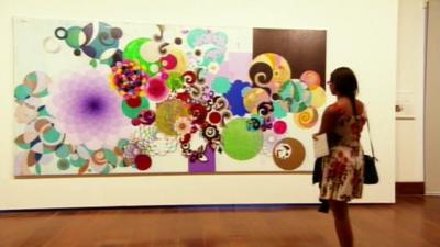 A woman admires a painting in Brazil