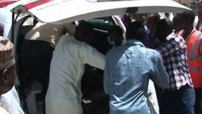 Family members gather outside a vehicle carrying a corpse in Damaturu on 29 September