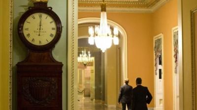 A clock outside the Senate chamber shows one minute past midnight