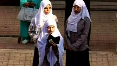 Three Muslim girls reading the Quran