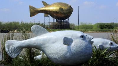 A viewing tower in the shape of a giant copper puffer fish