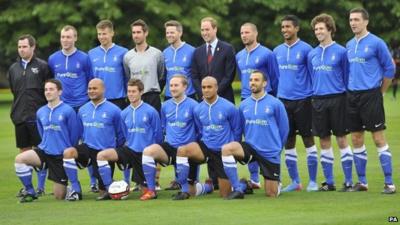 The Duke of Cambridge stands with members of the Polytechnic FC prior to their match against the Civil Service FC, in the grounds of Buckingham Palace"s garden