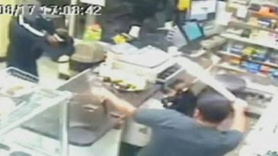 A shopkeeper pulls a machete on an armed robber