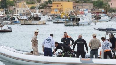 A team of divers with coast guards in Lampedusa harbour