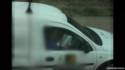 A driver reading behind the wheel