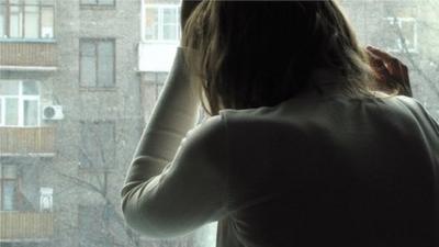 Woman leaning against a window