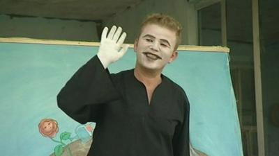 A mime actor waving to the audience.