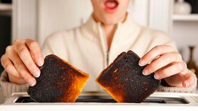 Taking burnt toast out of a toaster