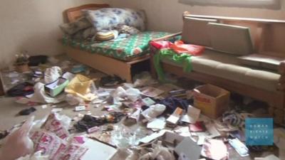 A room with scattered belongings on the floor