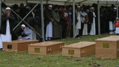 Mourners and four coffins