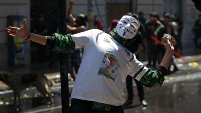 A Mapuche Indian activist prepares to throw a stone