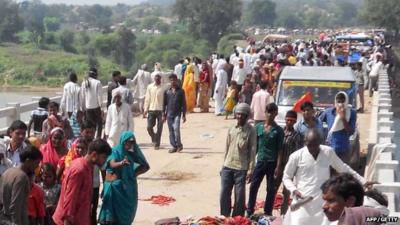 People gathered on the bridge following a stampede outside the Ratangarh Temple in Datia district, India"s Madhya Pradesh state