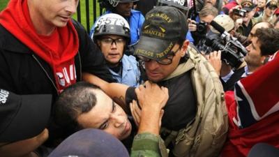 Protesters try to disengage some of their fellow demonstrators from a confrontation with law enforcement as they climb the wall and fence in front of the White House gates in Washington