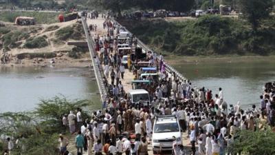 People cross a bridge after the stampede