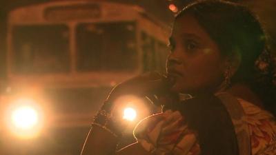 An Indian woman waits for a bus