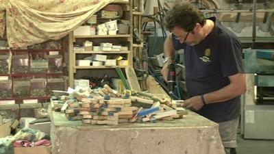 Francisco Tuccio makes crosses out of wood from the wreckage of migrant boats