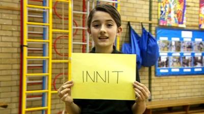 Girl holding sign reading 'innit'